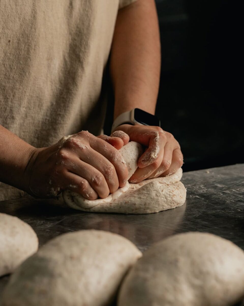 Una persona amasando una bola de pan de masa madre 