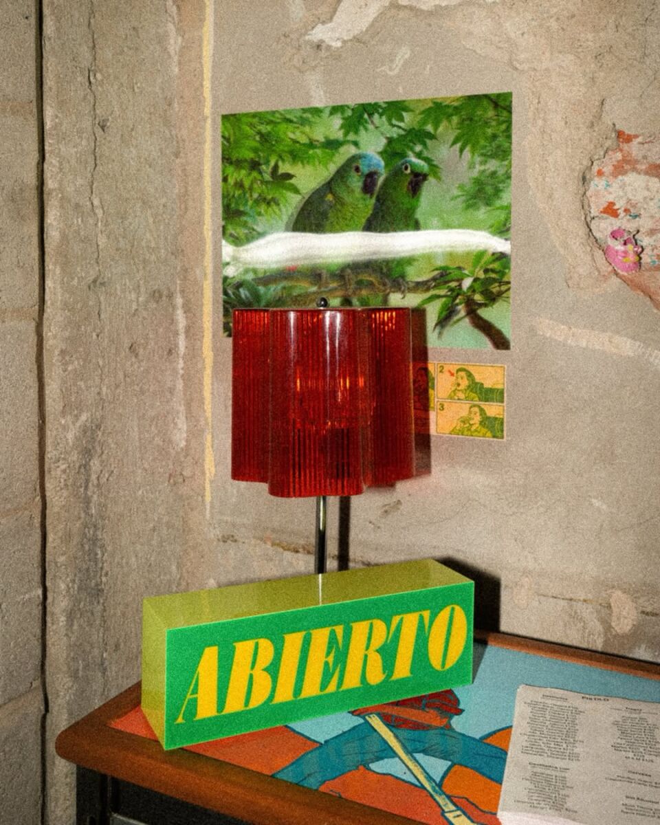 letrero verde con letras amarillas que dice "abierto", con una lámpara roja encima