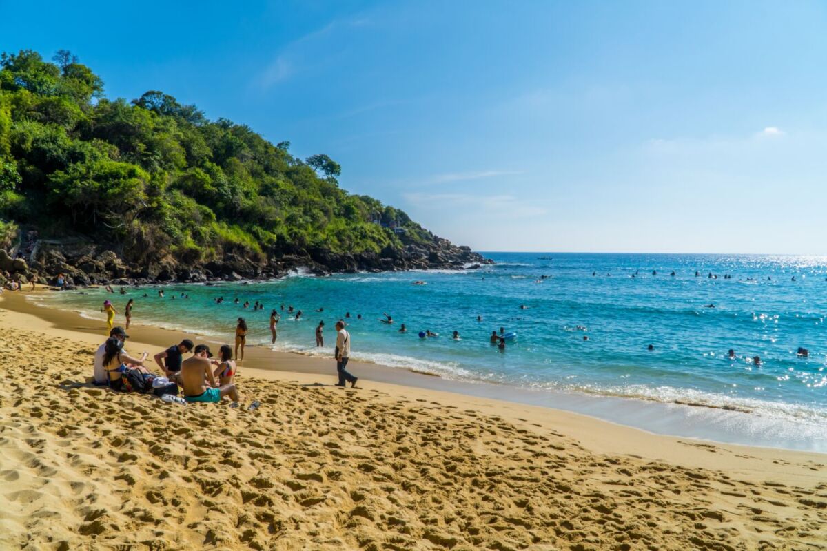 Vacacionistas nadando y disfrutando el sol en la Playa Carrizalillo, Oaxaca 