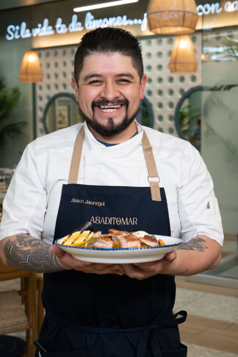 Chef de Asadito de Mar sosteniendo un platillo