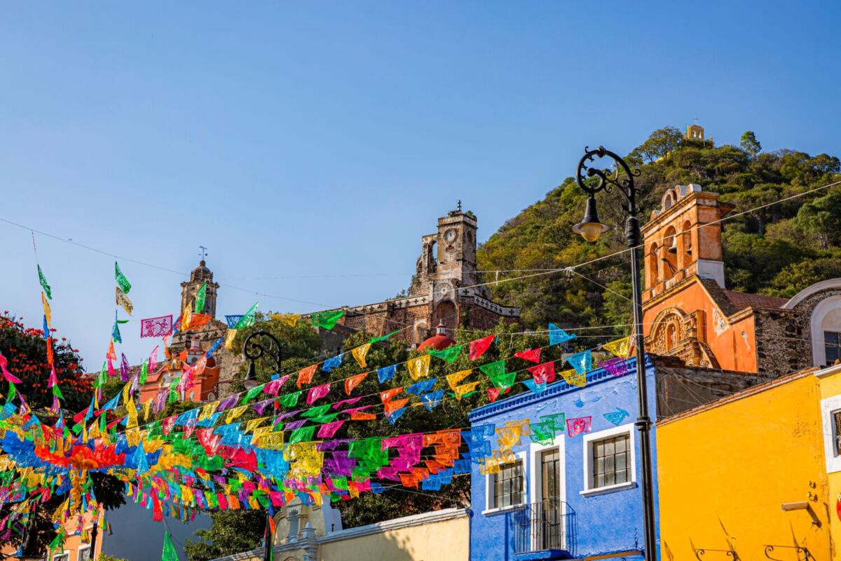 pueblo mexicano con casas coloridas, decorado con papel picado 