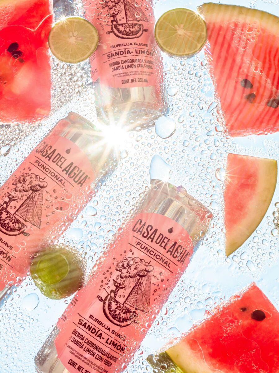 latas flotando en el agua con rebanadas de sandía y limones