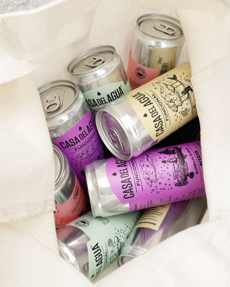 latas con etiquetas coloridas en una bolsa de tela