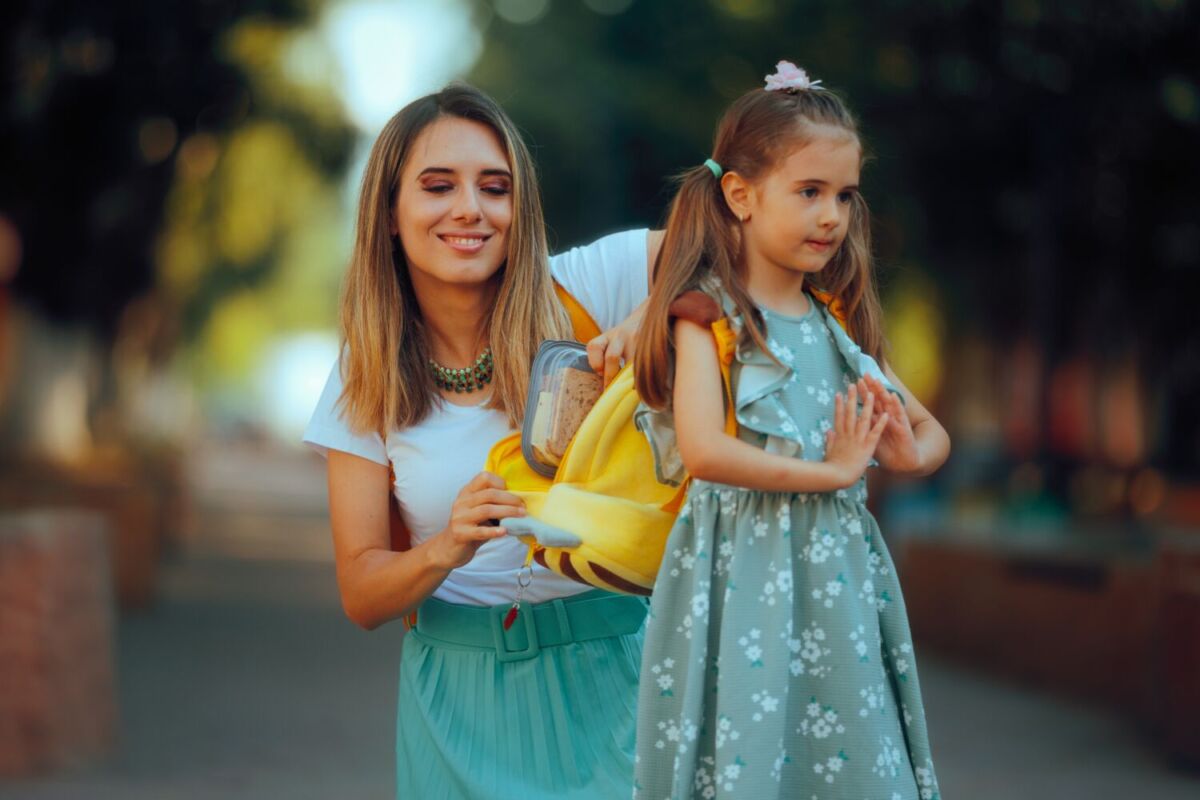 mamá poniendo el lunch a su hija 