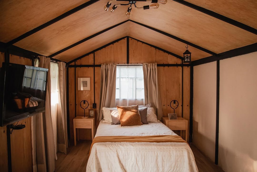 interior de una cabaña acogedora y rústica con una cama matrimonial
