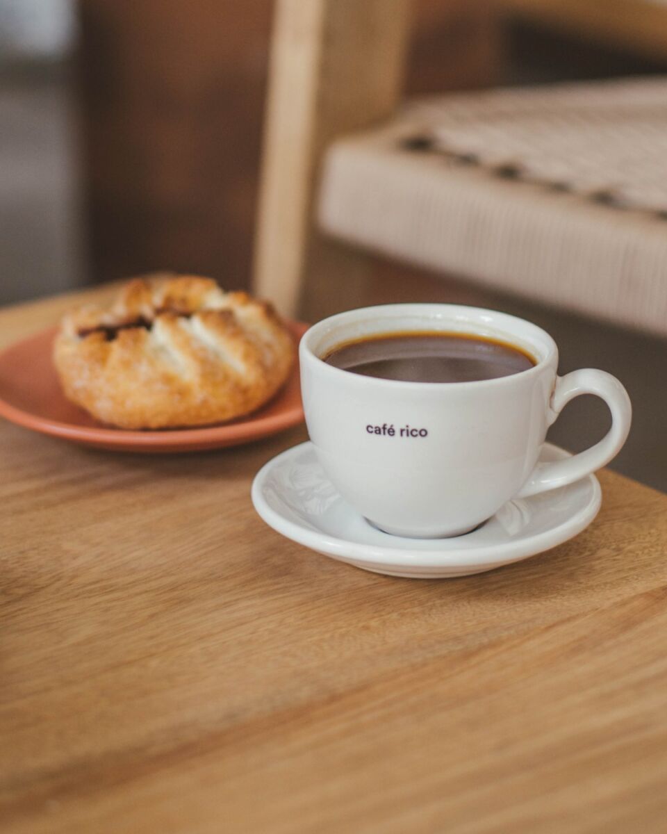 taza de café con un plato de pan