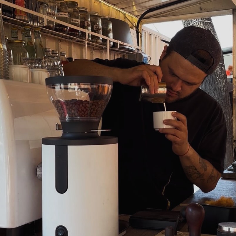 hombre preparando café de especialidad en un puesto callejero
