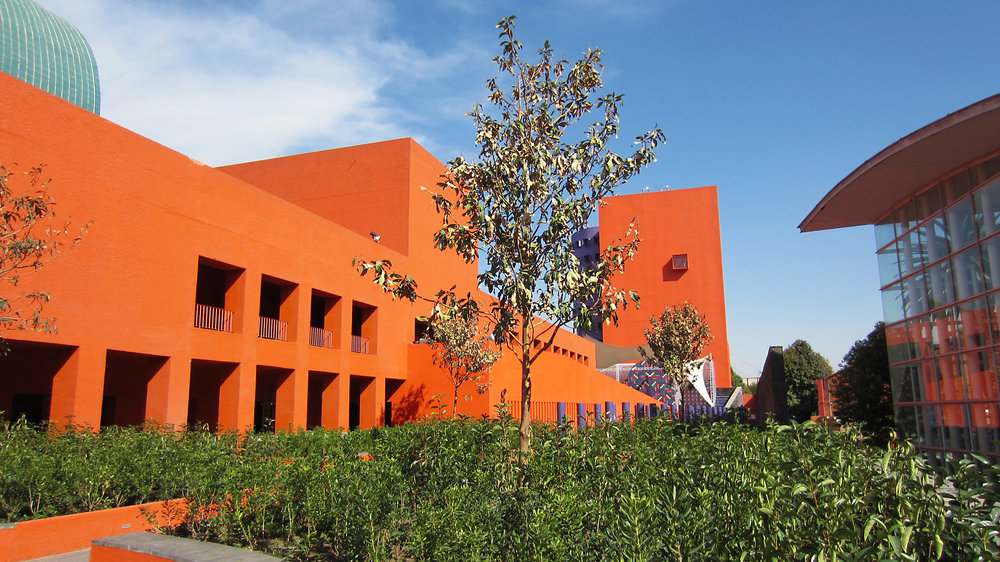 edificio moderno color naranja con un jardin