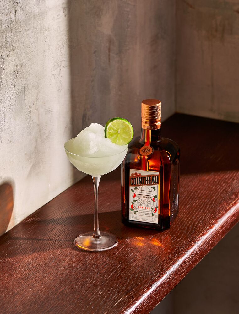botella de cointreau junto a una margarita de limón