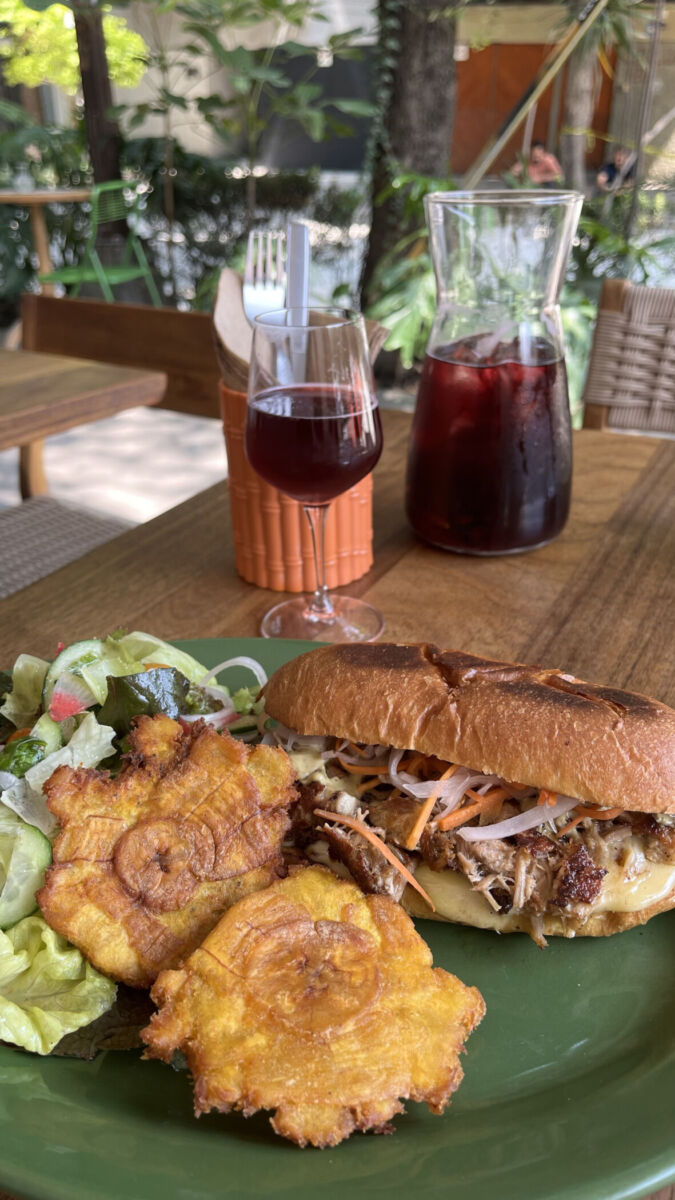 sándwich de pan brioche con pork belly, ensalada y tostones de plátano