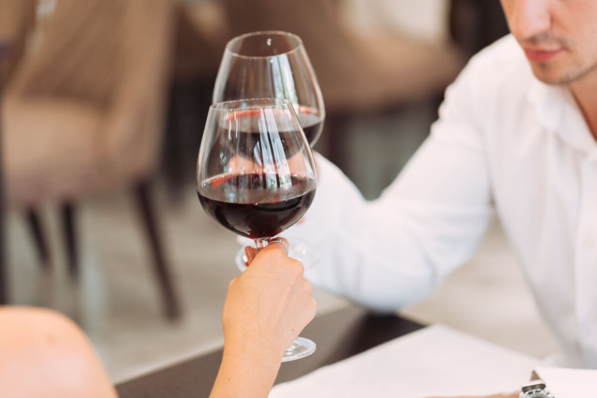 Personas agarrando unas copas de vino