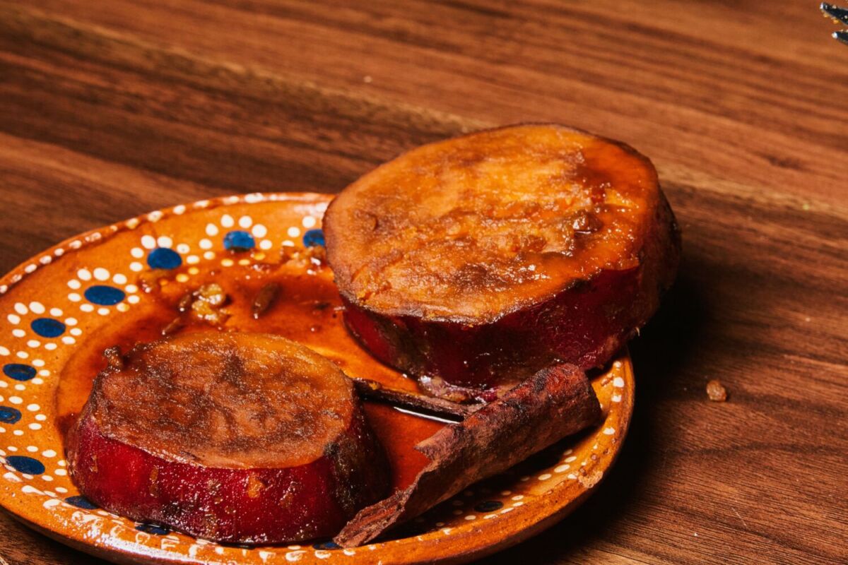 Camotes poblanos en plato de barro sobre mesa de madera, dulces típicos de Puebla, México