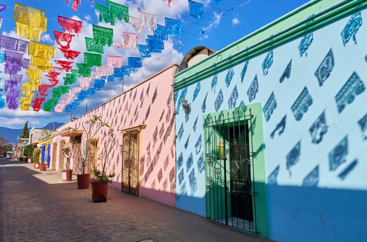 calle con casas coloridas y papel picado en Oaxaca, México