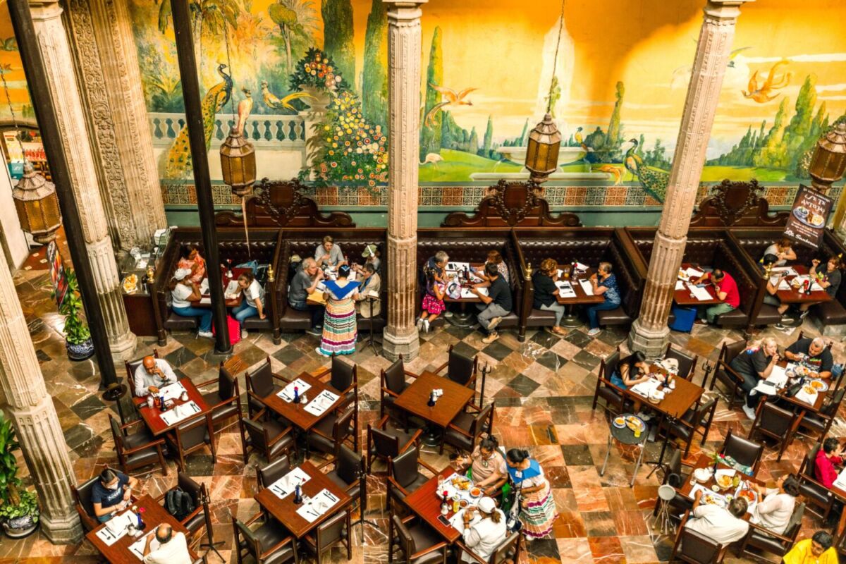Segundo piso Casa de los Azulejos con murales de pavos reales, balcones coloniales, azulejos poblanos y vista al patio central del restaurante Sanborns CDMX