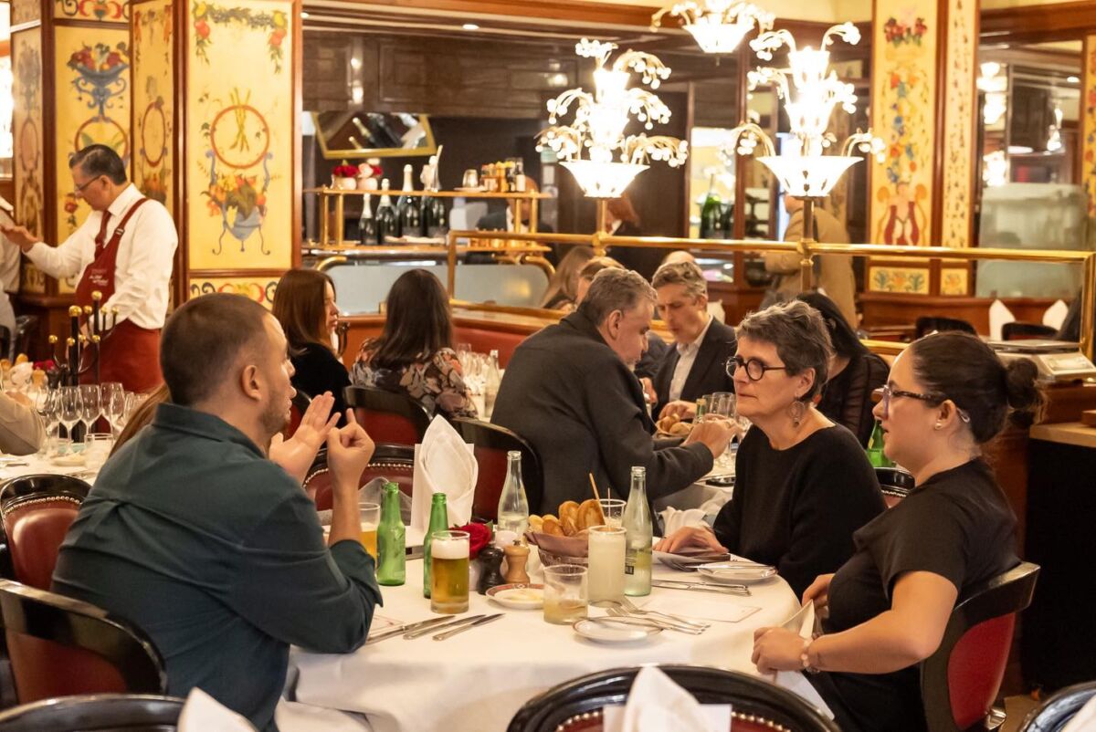 Interior restaurante Au Pied de Cochon Polanco con decoración parisina y comensales en mesas, Ciudad de México.