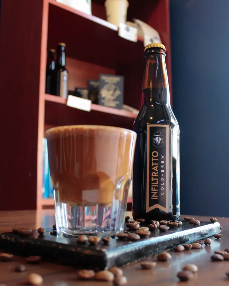 un cafe con chocolate junto a una botella de cafe