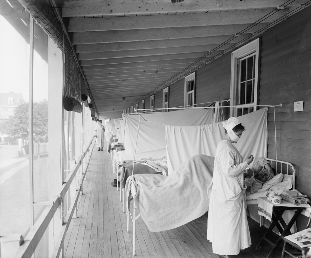 Enfermera con mascarilla atendiendo a un paciente contagiado de un virus 