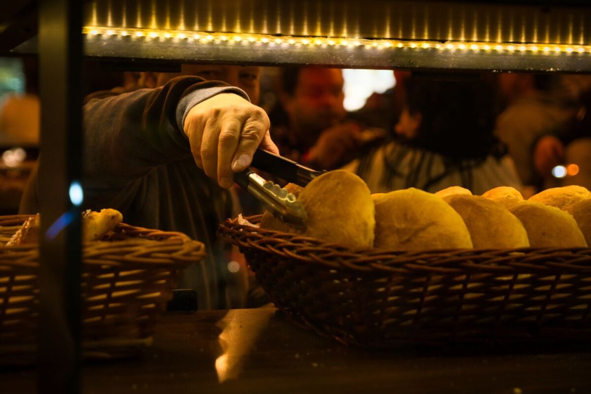 persona agarrando un pan dulce tradicional con unas pinzas