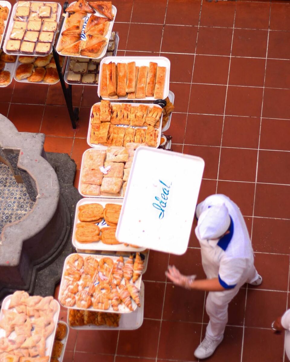 persona con charola de pan en panadería de ex-convento