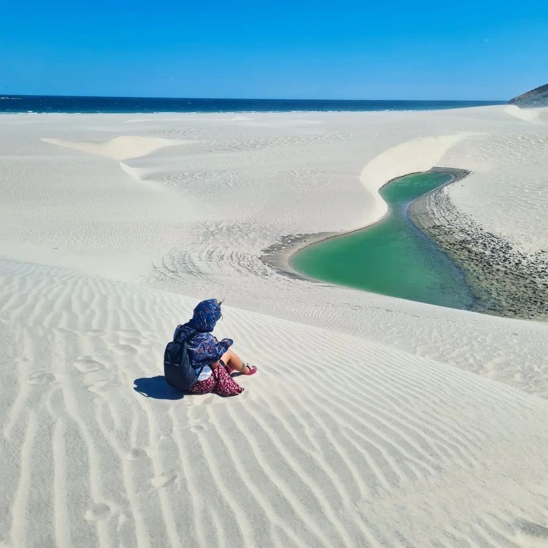 Turista observando una poza de agua en las dunas de Chipehua, Oaxaca