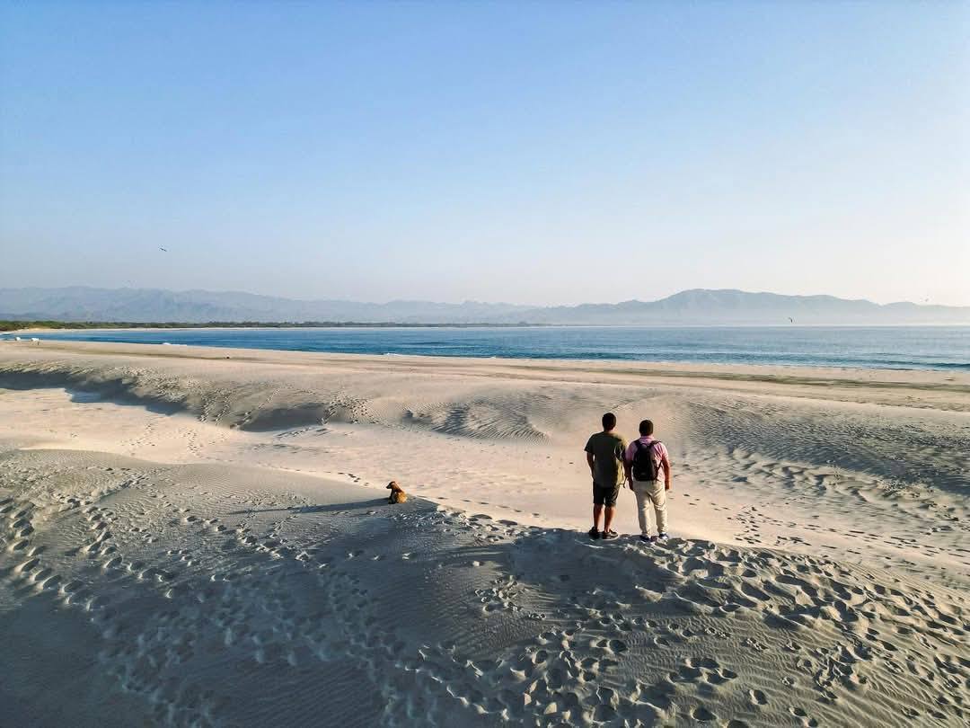 Dos turistas viendo el océano sobre las Dunas de Chipehua en Oaxaca 