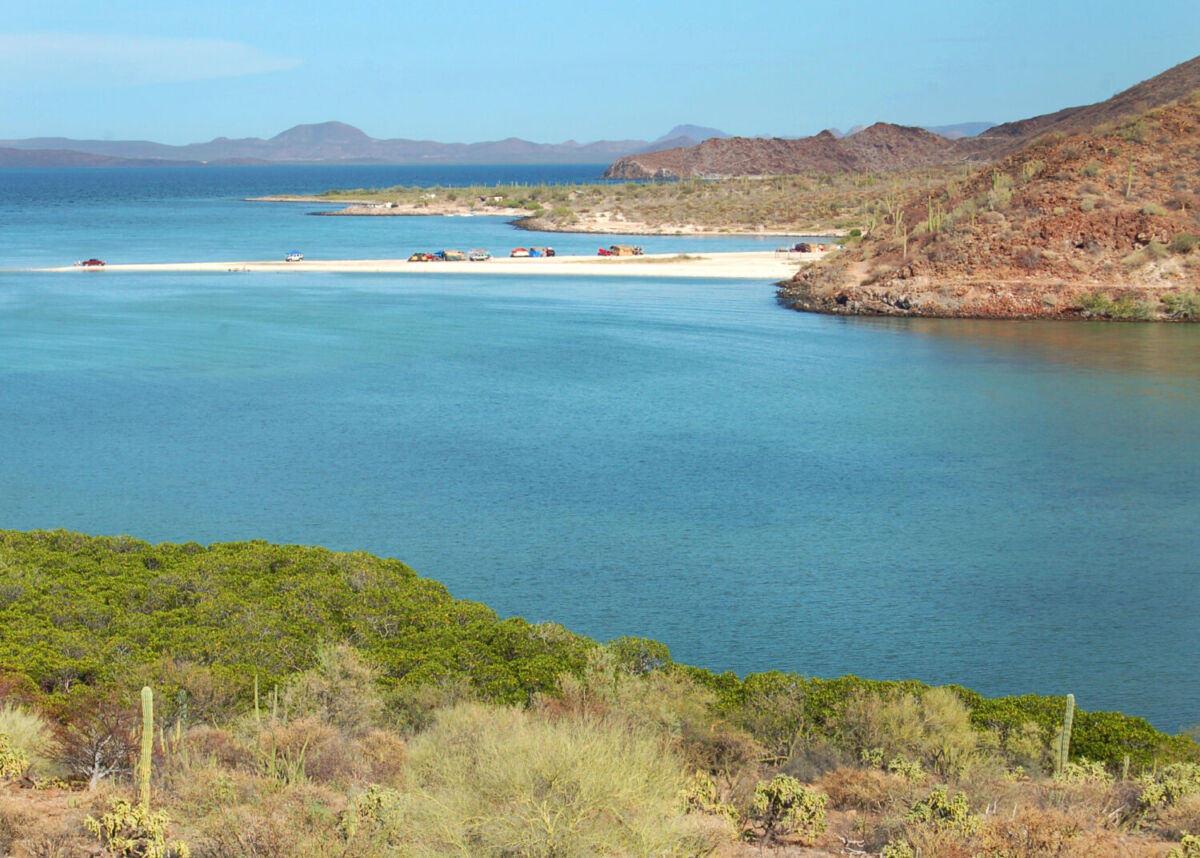 montañas rodeado una playa de agua turquesa 
