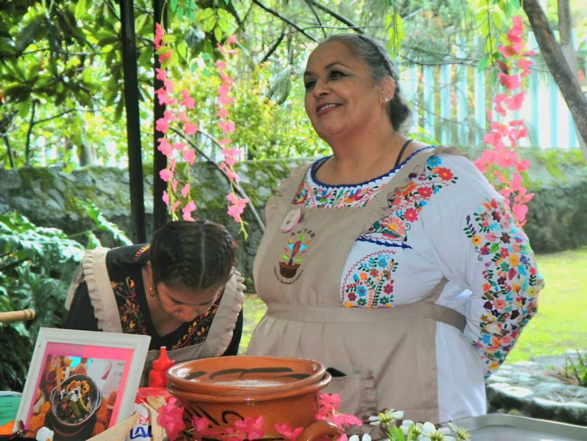 mujer parada frente a pozole negro