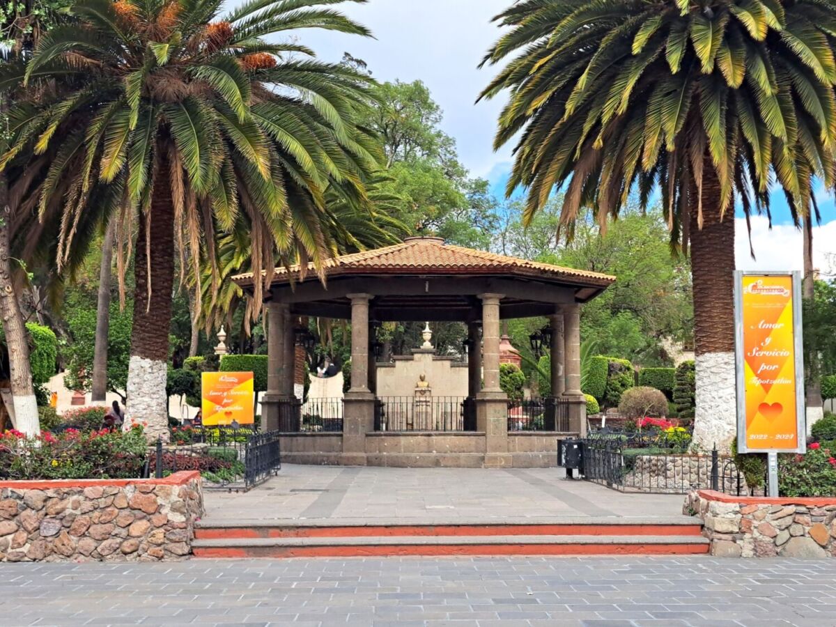 Kiosco colonial con columnas de cantera rodeado de palmeras en plaza central de Tepotzotlán, Estado de México