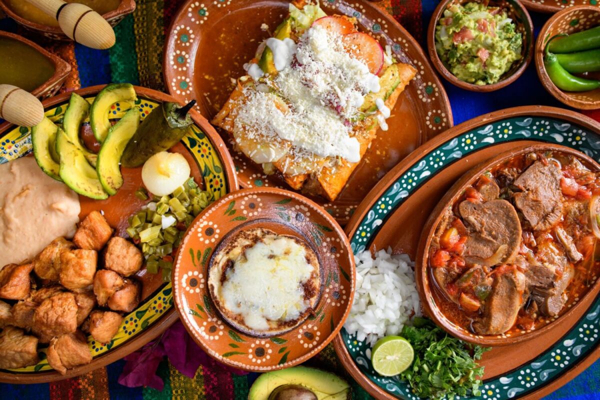 close up de una mesa mexicana con comida en platos de barro