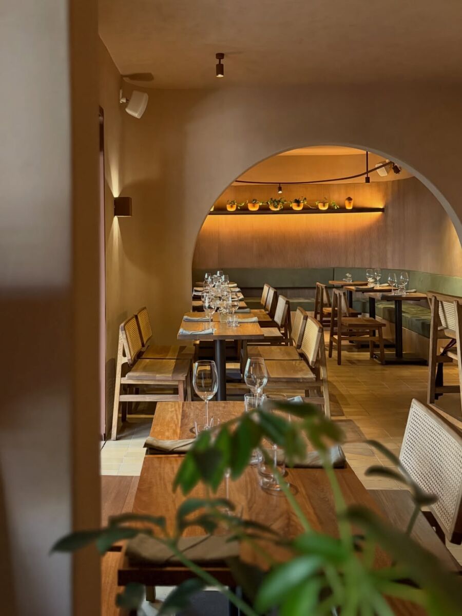 restaurante minimalista con luces cálidas y mesas de madera