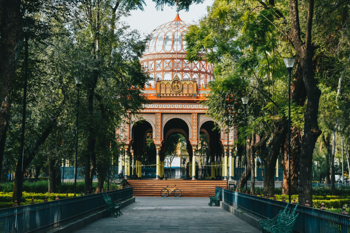 Kiosco Morisco en medio de una jardinera con árboles y bancas