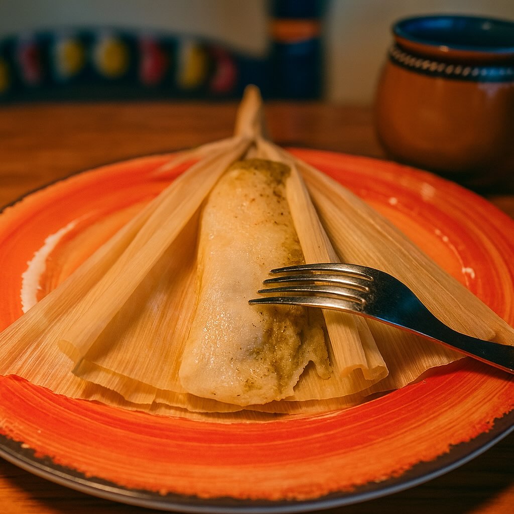 tamal verde abierto sobre un plato naranja