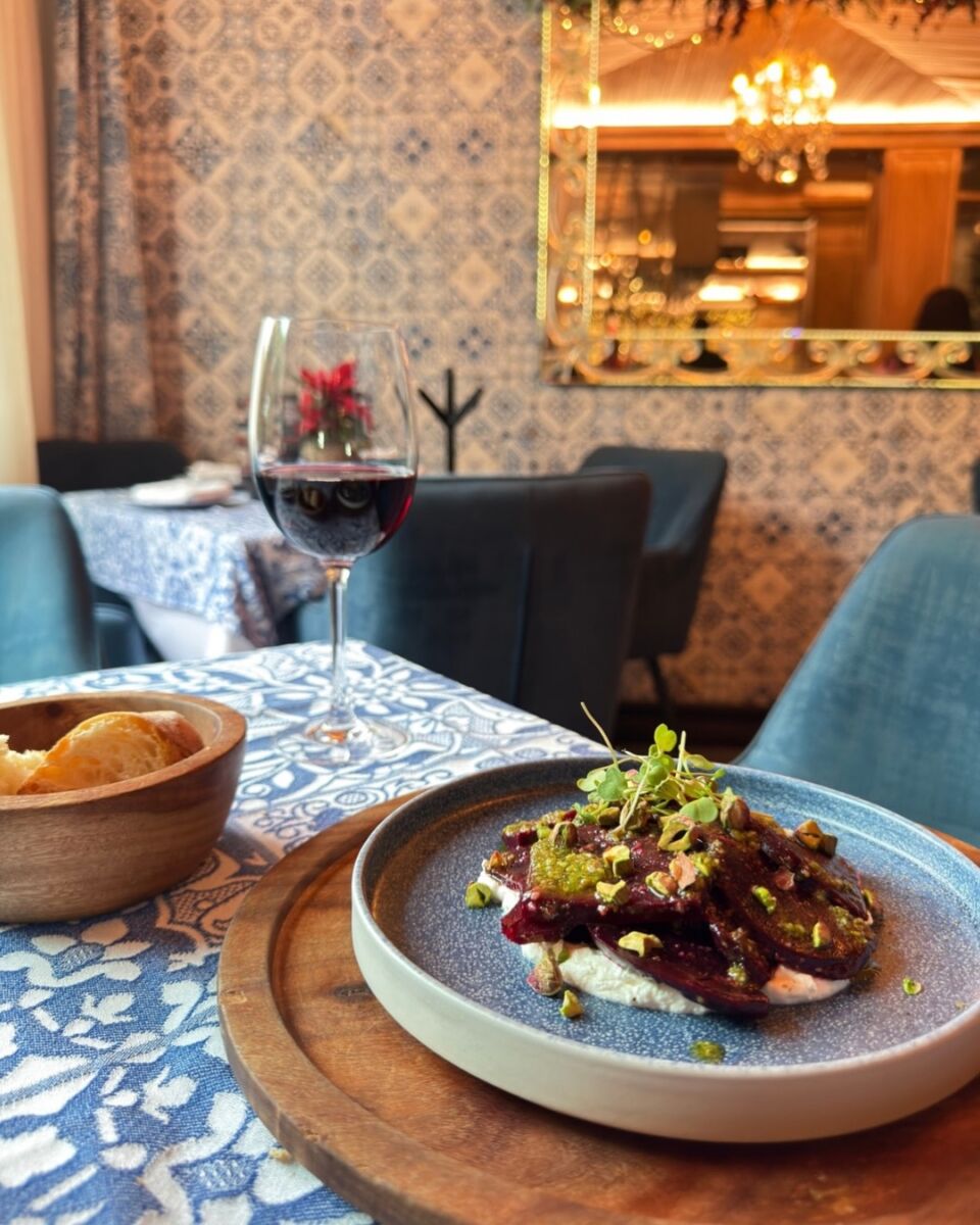 Platillo gourmet Casa Portuguesa con copa de vino tinto, pan artesanal y decoración azulejos portugueses, Polanco CDMX