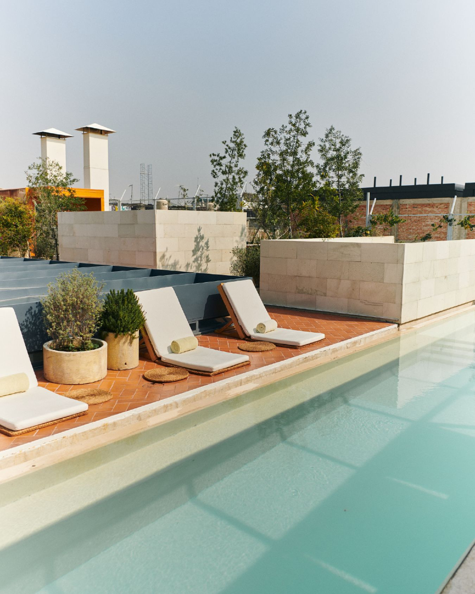 alberca minimalista con camastros en un rooftop