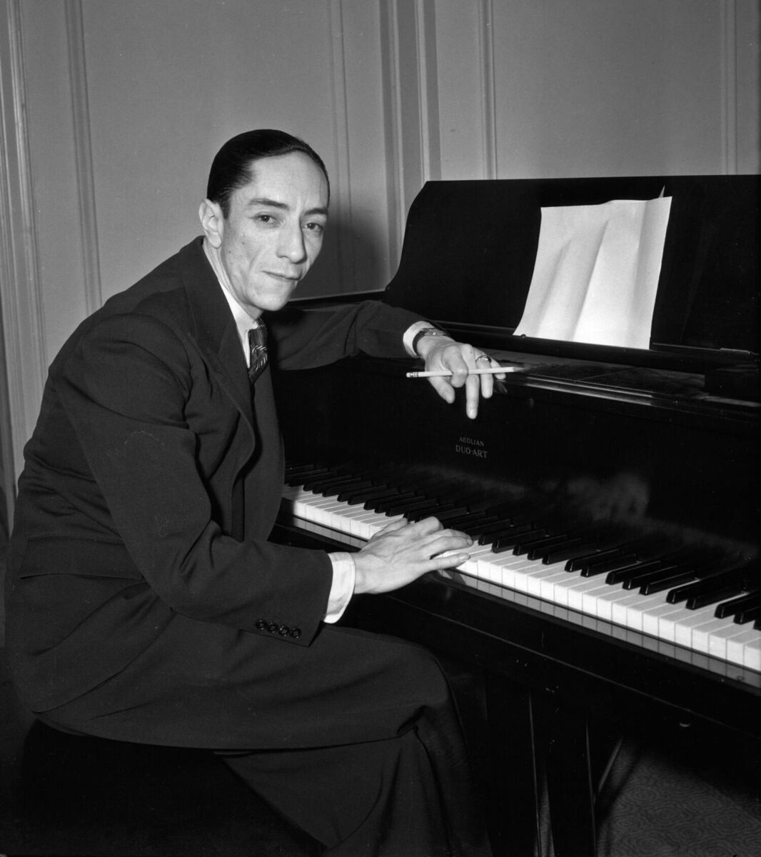 fotografía de Agustín Lara junto a un piano