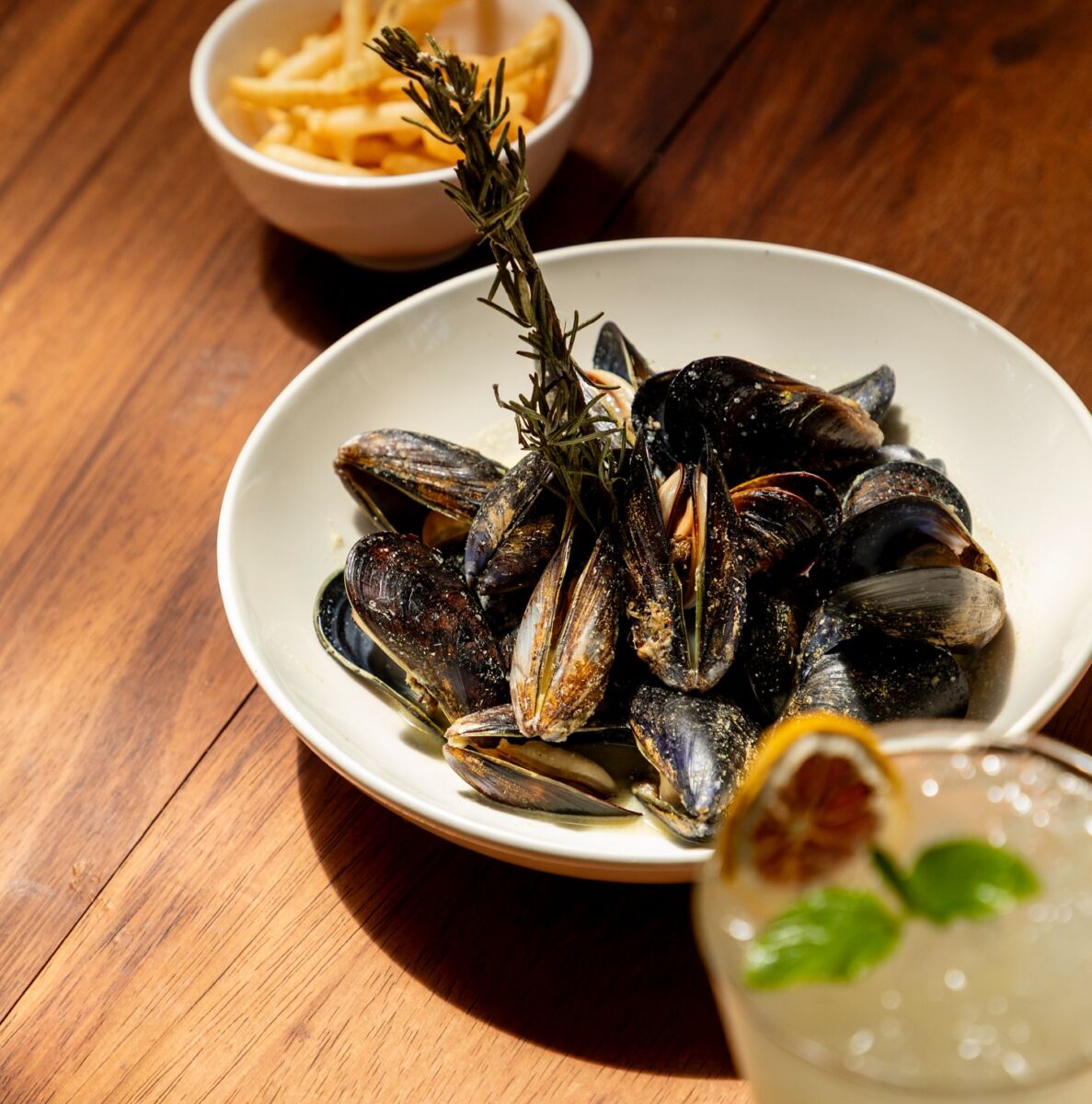 plato de mejillones con romero sobre una mesa de madera elegante