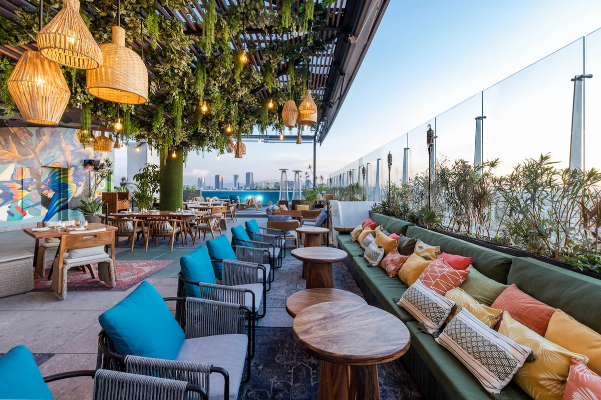terraza bohemia y elegante con muchas mesas y sillones