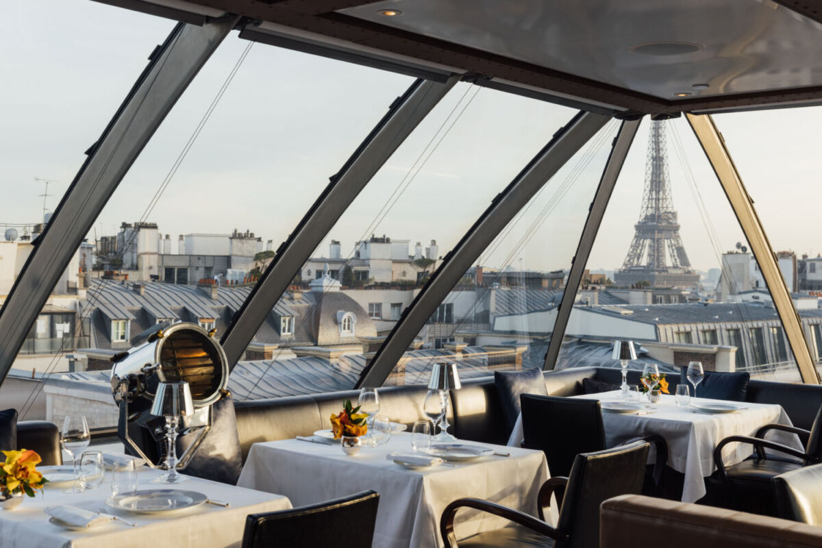 restaurante elegante con ventanales y vista a la torre eiffel