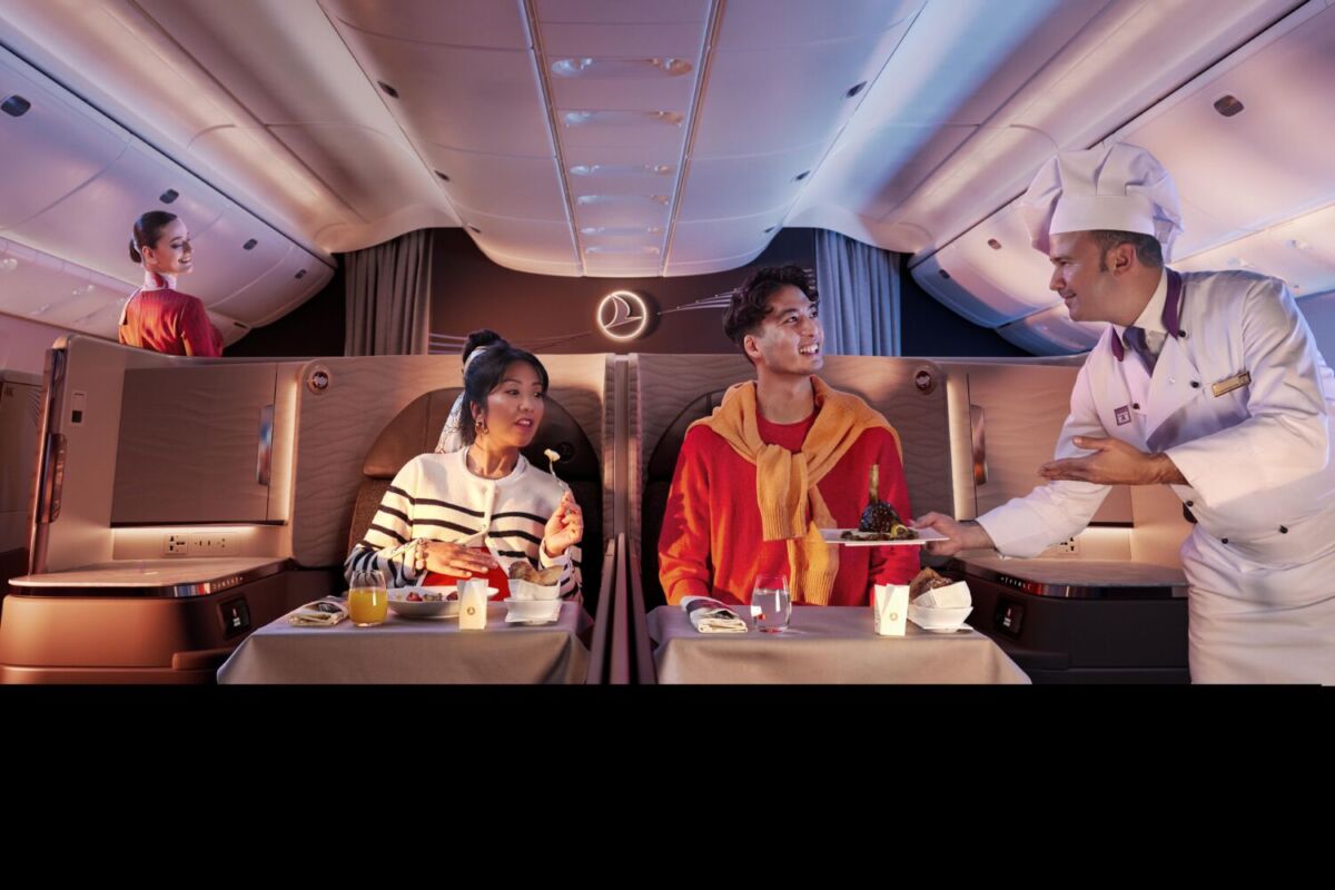 dos pasajeros en Business Class disfrutando el servicio de catering