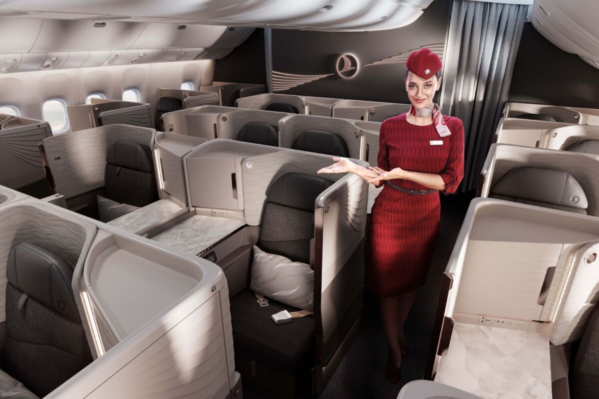 sobrecargo mostrando un asiento de Business Class