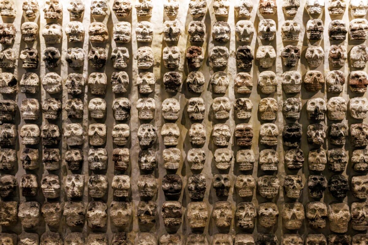 muro escultórico de cráneos tallados en piedra