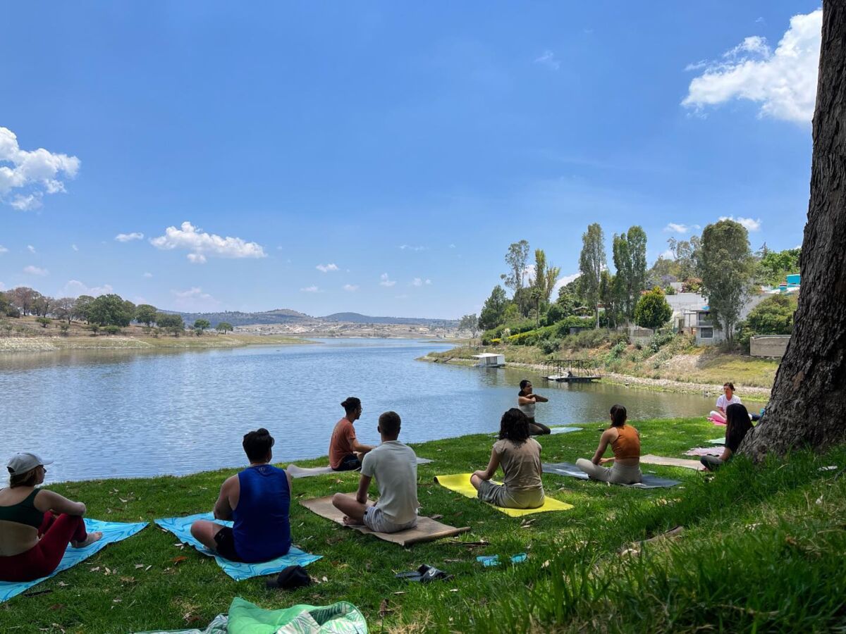 Un grupo de personas haciendo yoga frente a la Presa de Valsequillo
