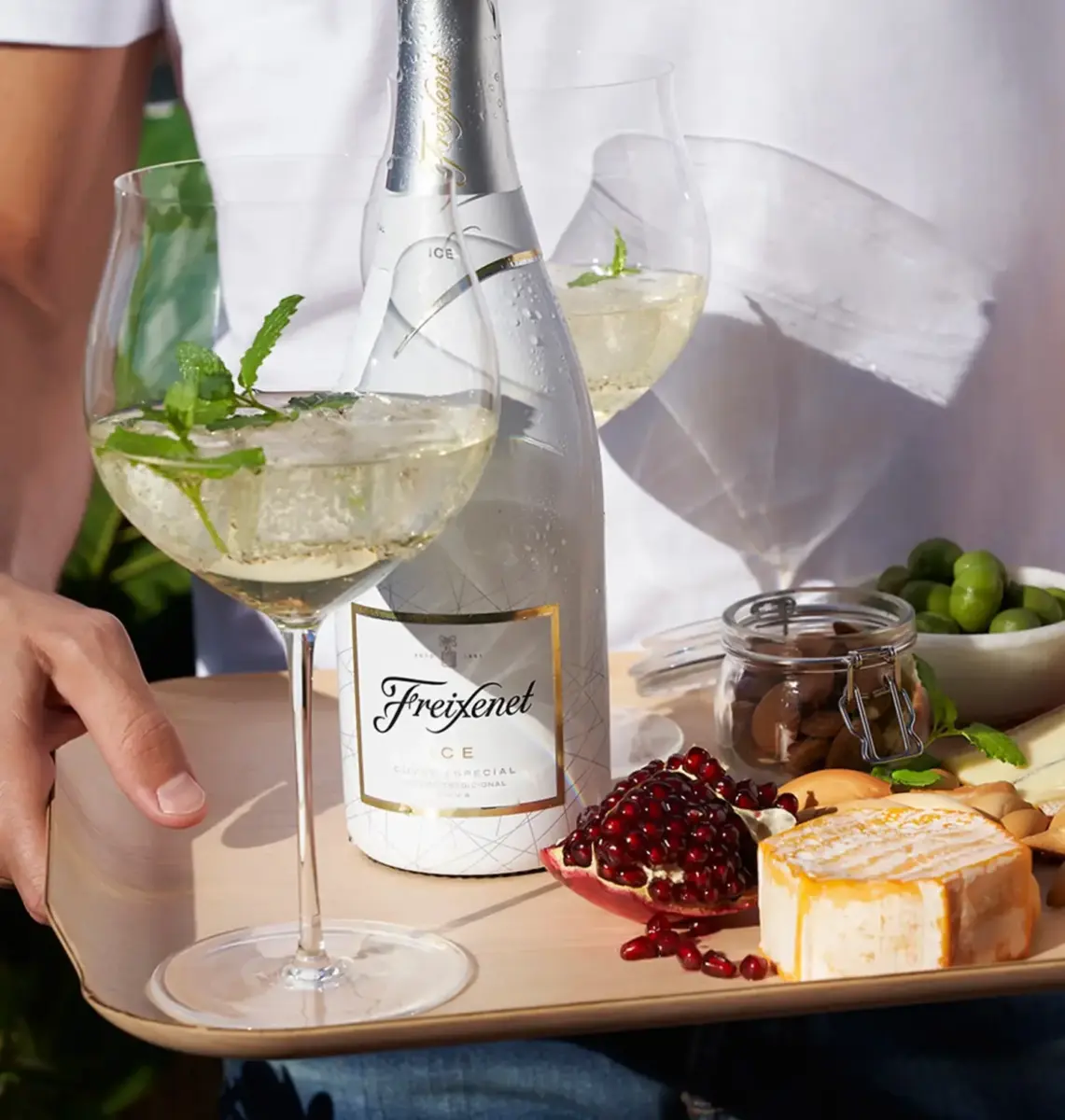 tabla de quesos con una copa de vino con hielo y una botella de freixenet ice cueva