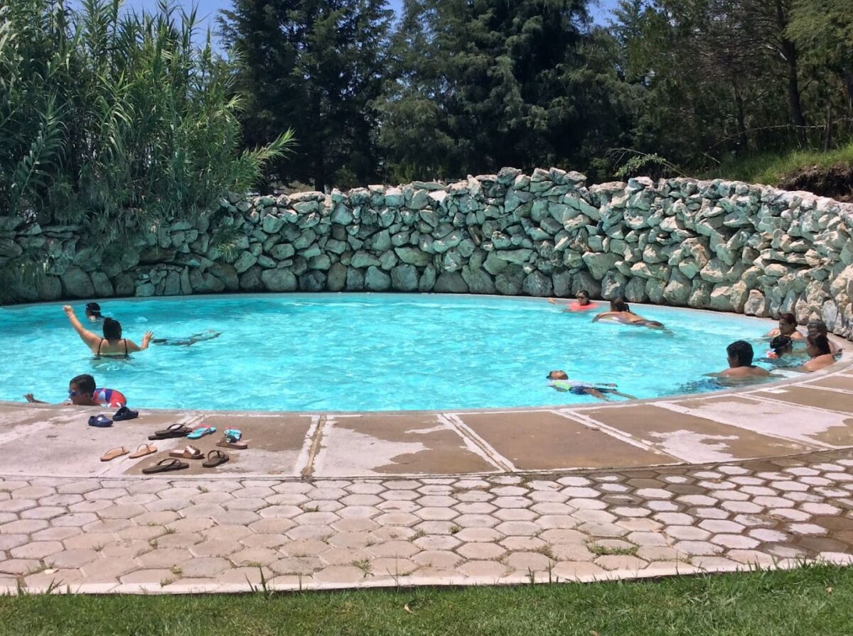 personas nadando en una alberca de agua termal 