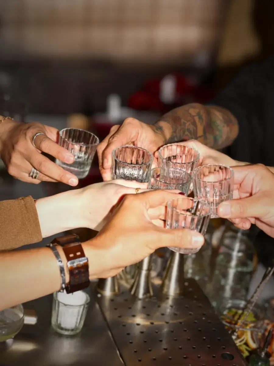 personas brindando con mezcal