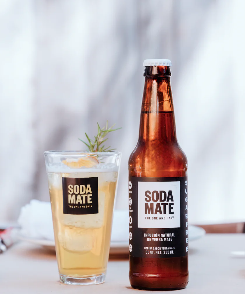 botella de soda mate junto a un coctel cítríco
