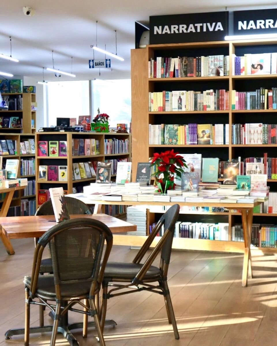 librería repleta de libos, una mesa y dos sillas