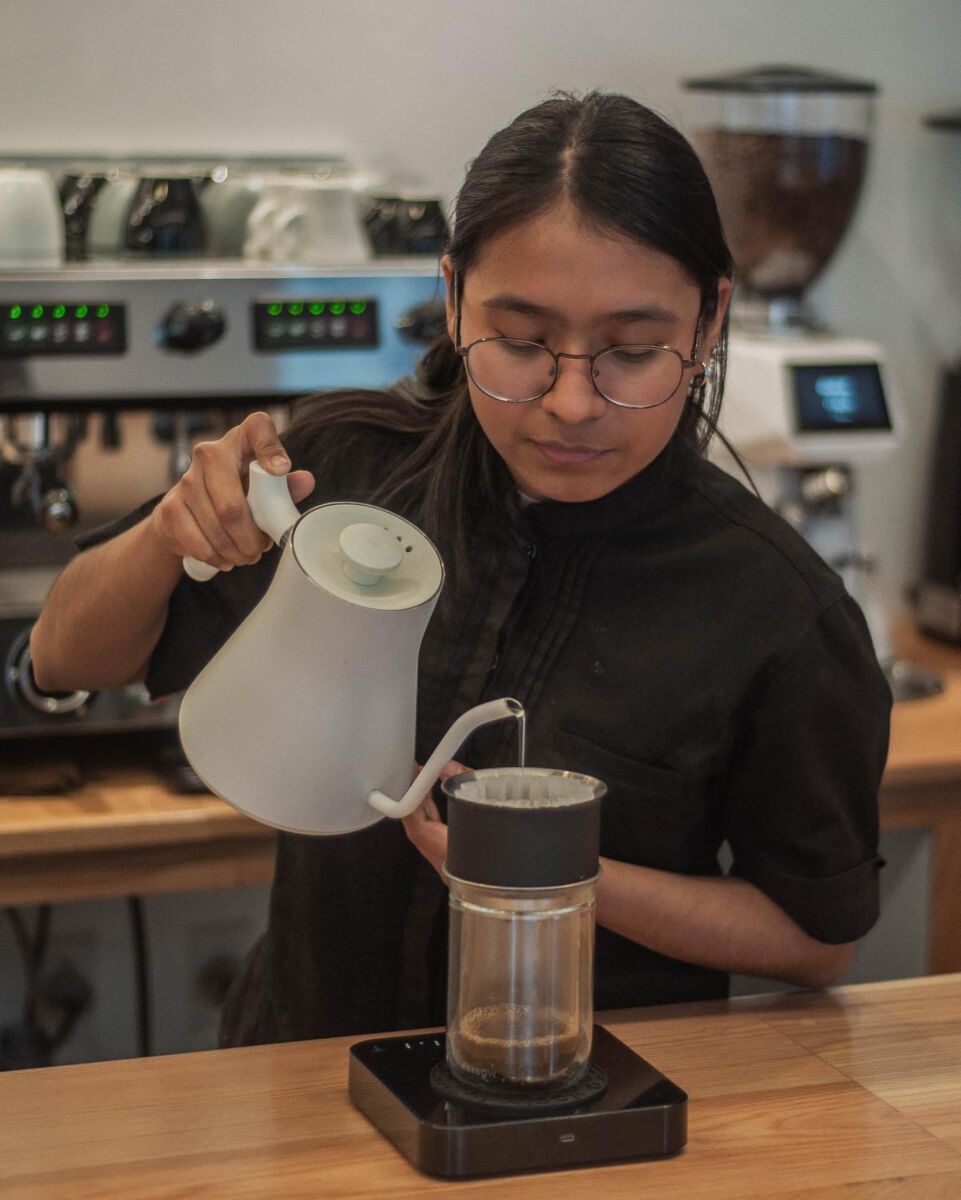 mujer preparando café en una prensa francesa