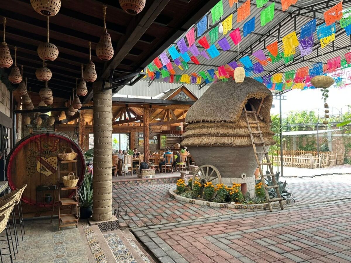 La enorme troje de barro y palma es uno de los elementos más llamativos de Casa Mashihua, rodeada de artesanías y coloridos papeles picados.