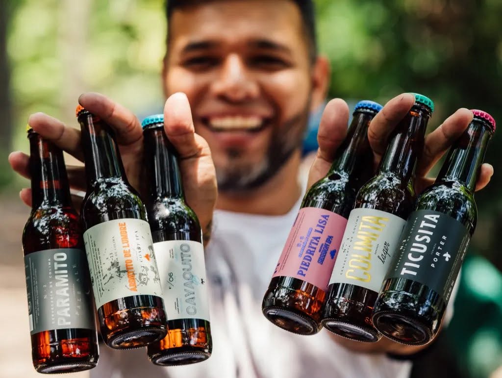 persona mostrando seis botellas pequeñas de cerveza